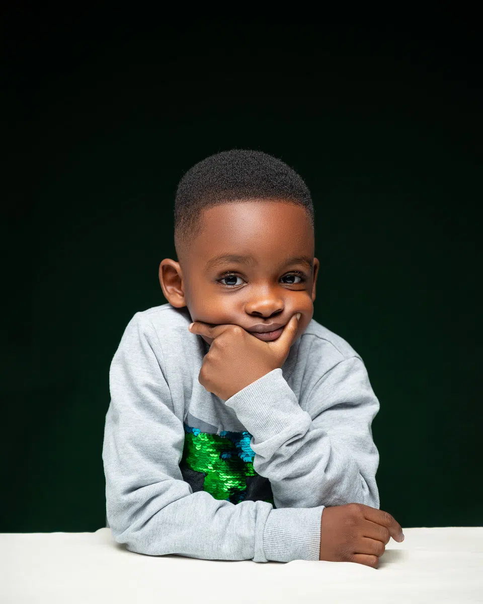 Young child model building camera confidence with DXC Models in Lagos